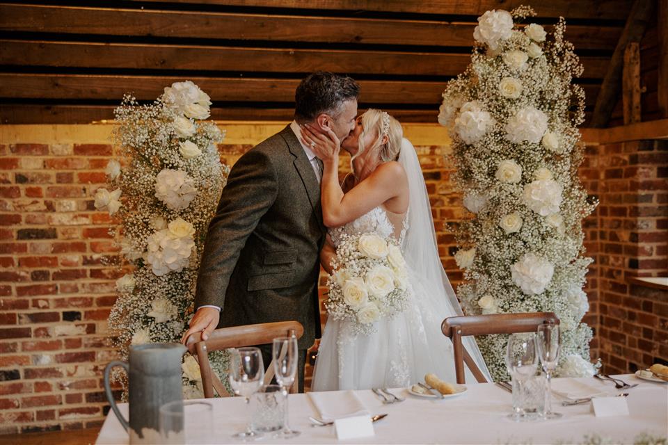 The barn at Redcoats sweetheart table set up with floral pillars